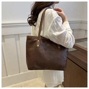 Borsa tote marrone con design patchwork a rilievo e borchie dorate sulle tracolle