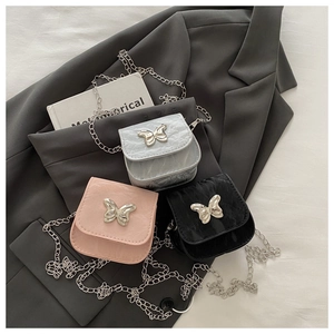 Detailed view of mini chain bags in silver, pink, and black with butterfly charms
