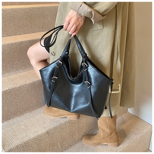 Détail d'un grand sac cabas vintage noir avec boucle argentée porté à l'épaule