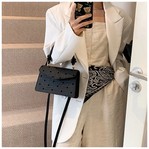 Mirror selfie showing the black polka dot denim crossbody bag on a casual outfit