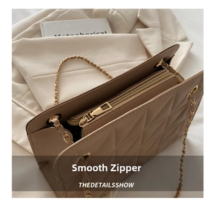 Close-up of beige quilted chain tote bag with high-quality gold hardware and zipper