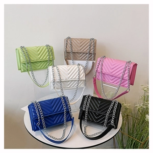 Détail de sacs à main matelassés en V aux couleurs acidulées avec bandoulière chaîne