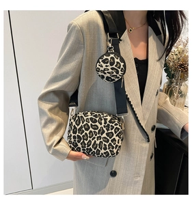 Detail of leopard print crossbody bag with mini pouch and golden hardware accents
