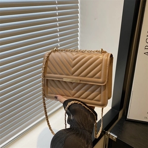 Beige quilted chain crossbody bag with V-shaped stitching and gold-tone metal hardware