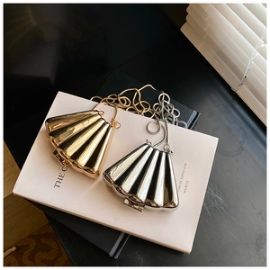 Detailed view of gold and silver shell-shaped evening bags with metallic pleated texture