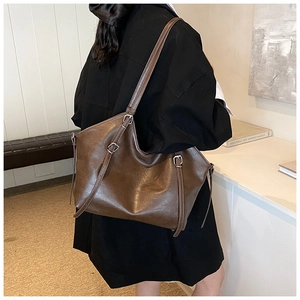 Détail du grand sac cabas vintage marron avec bandoulières réglables et boucles argentées