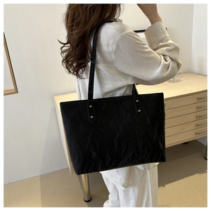 Détails du sac cabas noir minimaliste avec texture froissée et rivets argentés chic