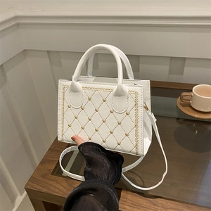 Elegant white quilted crossbody bag with golden heart embroidery and dual top handles