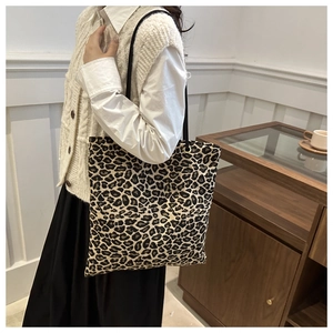 Vista de detalle del bolso tote con estampado de leopardo y asas negras finas puesto