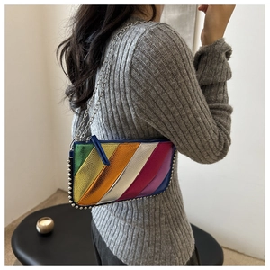 Detail of a rainbow metallic patchwork crossbody bag with silver rivets and chain strap