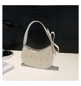 Close-up of floral lace shoulder bag with a decorative 3D green bow detail