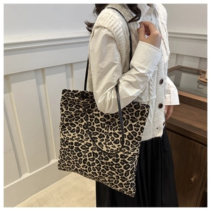 Close-up of leopard print tote bag showing the textured canvas material and black straps
