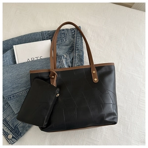 Dettagli della borsa tote nera con cuciture geometriche e finiture color bronzo