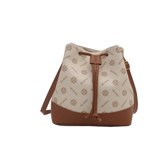 Chic beige bucket bag with caramel brown leather trim and retro geometric pattern