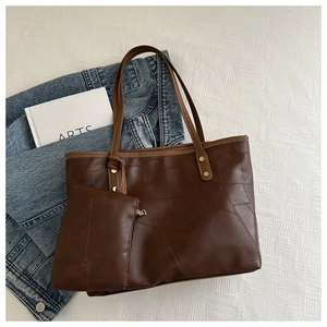 Vista piatta della borsa tote patchwork marrone scuro con pochette e giacca in denim