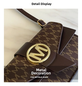 Detailed macro view of gold-tone metal M-buckle and textured monogram leather handbag
