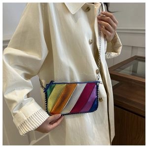 Detailed shot of rainbow striped metallic crossbody bag with silver rivet edge and chain