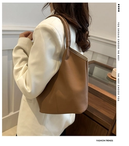 Detail of brown litchi pattern leather texture on a minimalist tote shoulder bag