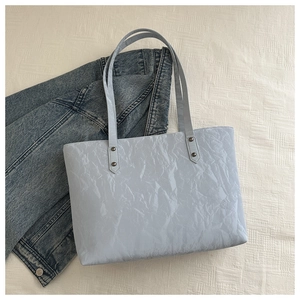 Gros plan du sac fourre-tout bleu clair avec texture froissée et fines bandoulières
