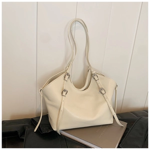 Détail du sac cabas en cuir crème avec boucles argentées et longues anses souples