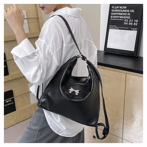 Dettaglio della borsa tote in pelle nera con fiocco in metallo argento e zip metallica