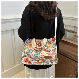 Floral canvas tote bag with adjustable strap worn by a model in a minimalist setting