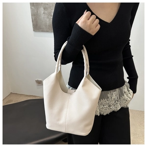 Close-up of cream white lychee texture bucket bag shown with elegant lifestyle styling