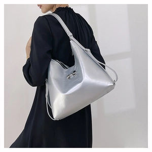 Dettaglio di una borsa tote argento metallizzato con fiocco decorativo e pelle lucida