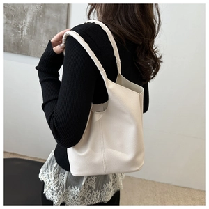 Detail view of white lychee pattern bucket bag showing textured leather on a model