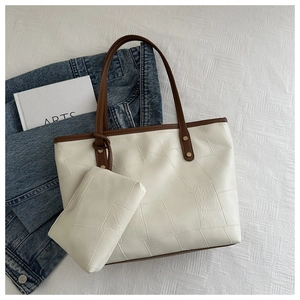 Dettaglio della borsa tote patchwork bianco sporco e marrone con pochette e rivetti