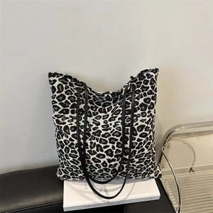 Minimalist leopard print jacquard tote bag with leather straps and metallic accents