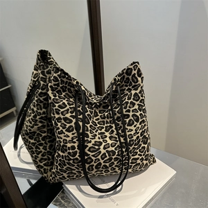 Vintage leopard print tote bag with black shoulder straps on white book aesthetic