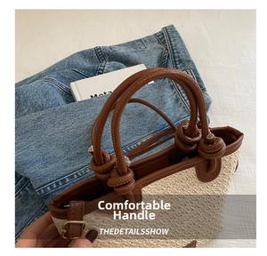 Détail du sac à main en paille avec anses en cuir marron et nœuds sphériques décoratifs