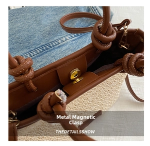 Détail du fermoir magnétique et garniture en cuir sur un sac cabas en paille tissée