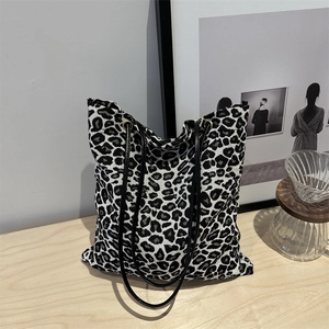 Modern black and white leopard print canvas tote bag with slim black leather handles