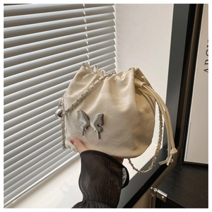 Détail du sac seau blanc avec papillon en métal argenté et cordon de serrage