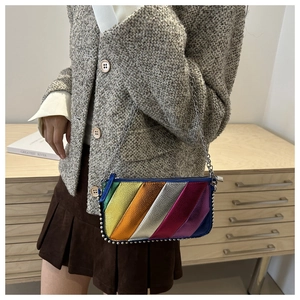 Detail of colorful rainbow striped crossbody bag with silver bead trim and metal chain