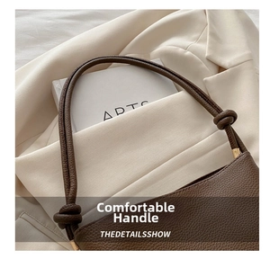 Detailed close-up of dark brown lychee pattern leather handbag with creative knot strap