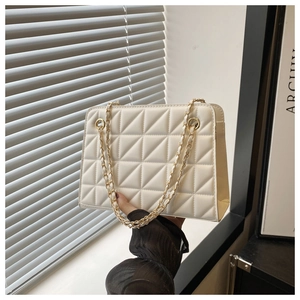 Close-up of white quilted chain bag with geometric triangle stitching and gold hardware