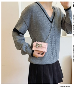Detail of pink mini crossbody bag with metallic silver butterfly and elegant chain strap