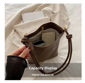 Detail of dark brown leather phone bag showing interior capacity with magnetic closure