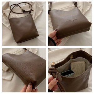 Detail view of brown lychee grain leather crossbody bag with knot strap and magnetic snap