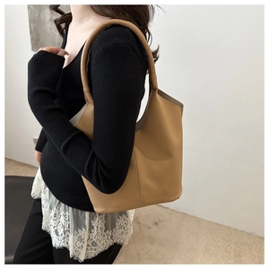 Detail shot of mustard yellow tote bag showing textured lychee leather and vertical stitching