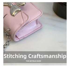 Detail shot of precise stitching and leather texture on a pink mini bow crossbody bag