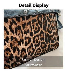 Detail of leopard print handbag featuring silver studs and metal chain strap on denim