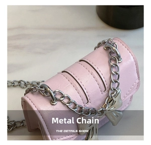 Close-up of pink leather mini bag featuring silver chain and metal bow charm details