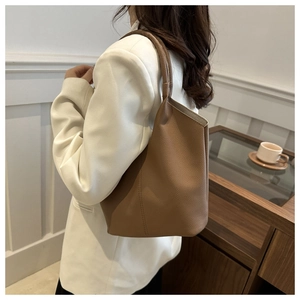Detail of dark brown lychee leather bucket bag with premium stitching and handle
