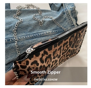 Close-up of smooth silver zipper and metal chain strap on leopard print square bag