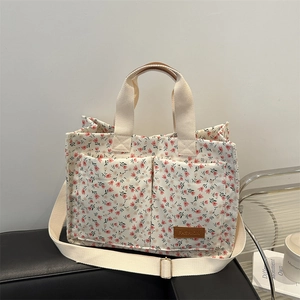 Floral canvas tote bag with dual front pockets and adjustable shoulder strap for women