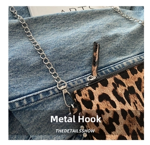 Detail of leopard print bag featuring a silver metal chain link and hardware lobster hook